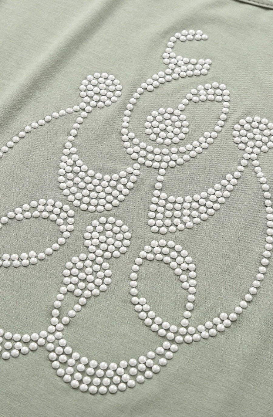 Close-up of pearl beads tracing the Arabic word Ishq on the Ishq pearl tee in Sage