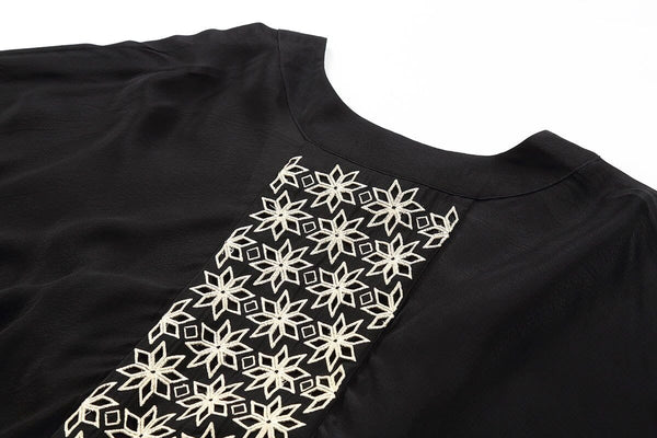 Close-up of the ivory star embroidery on the back panel of the Layla kimono in Midnight Black